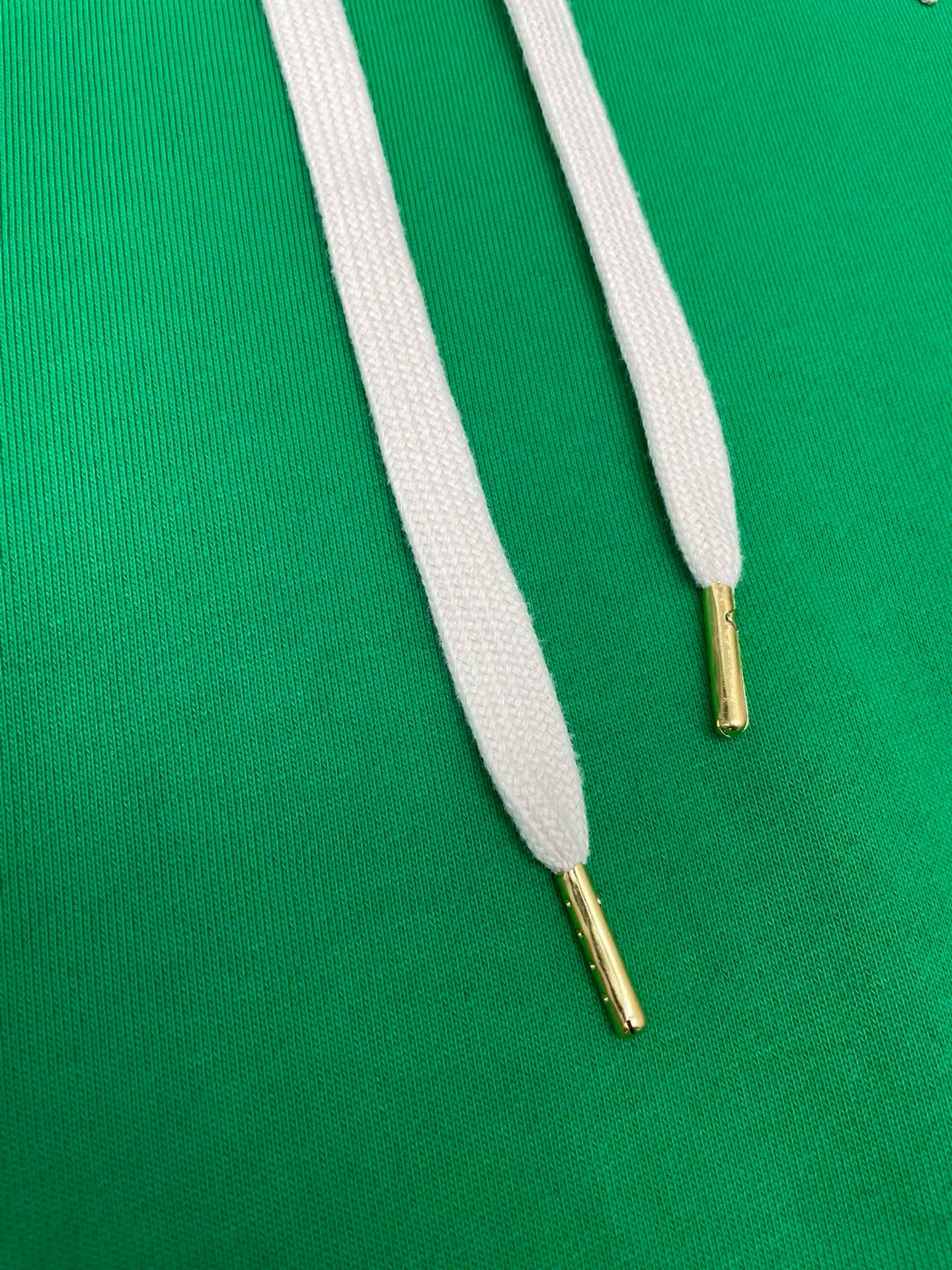 Grüner und schwarzer Kapuzenpullover