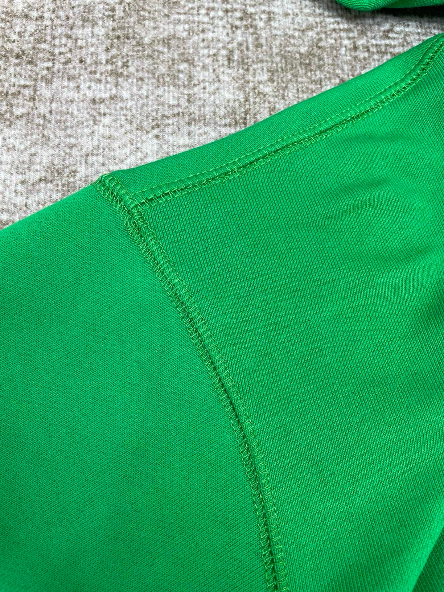 Grüner und schwarzer Kapuzenpullover