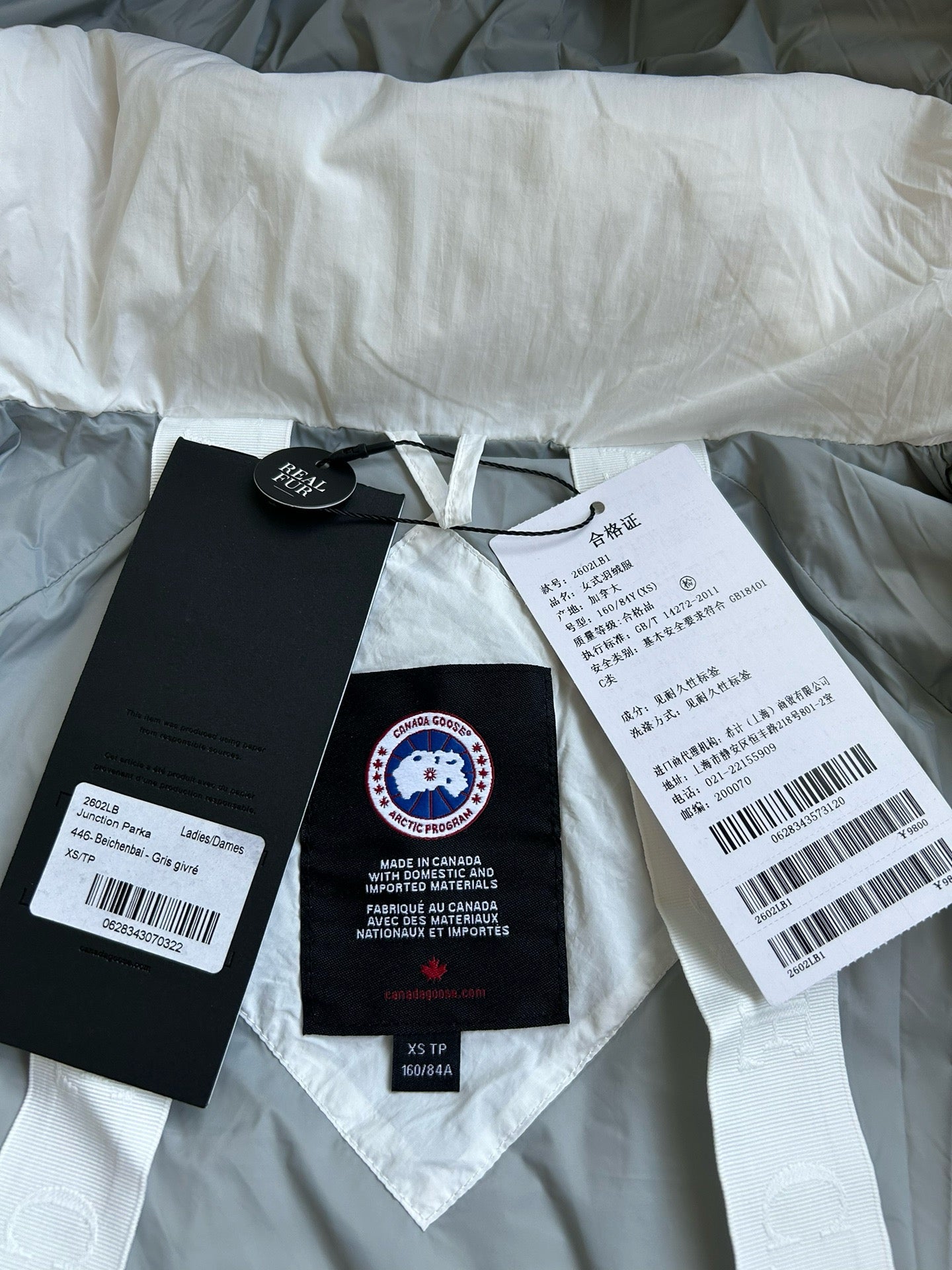 Weiße, khakifarbene, hellrosa und graue Jacke