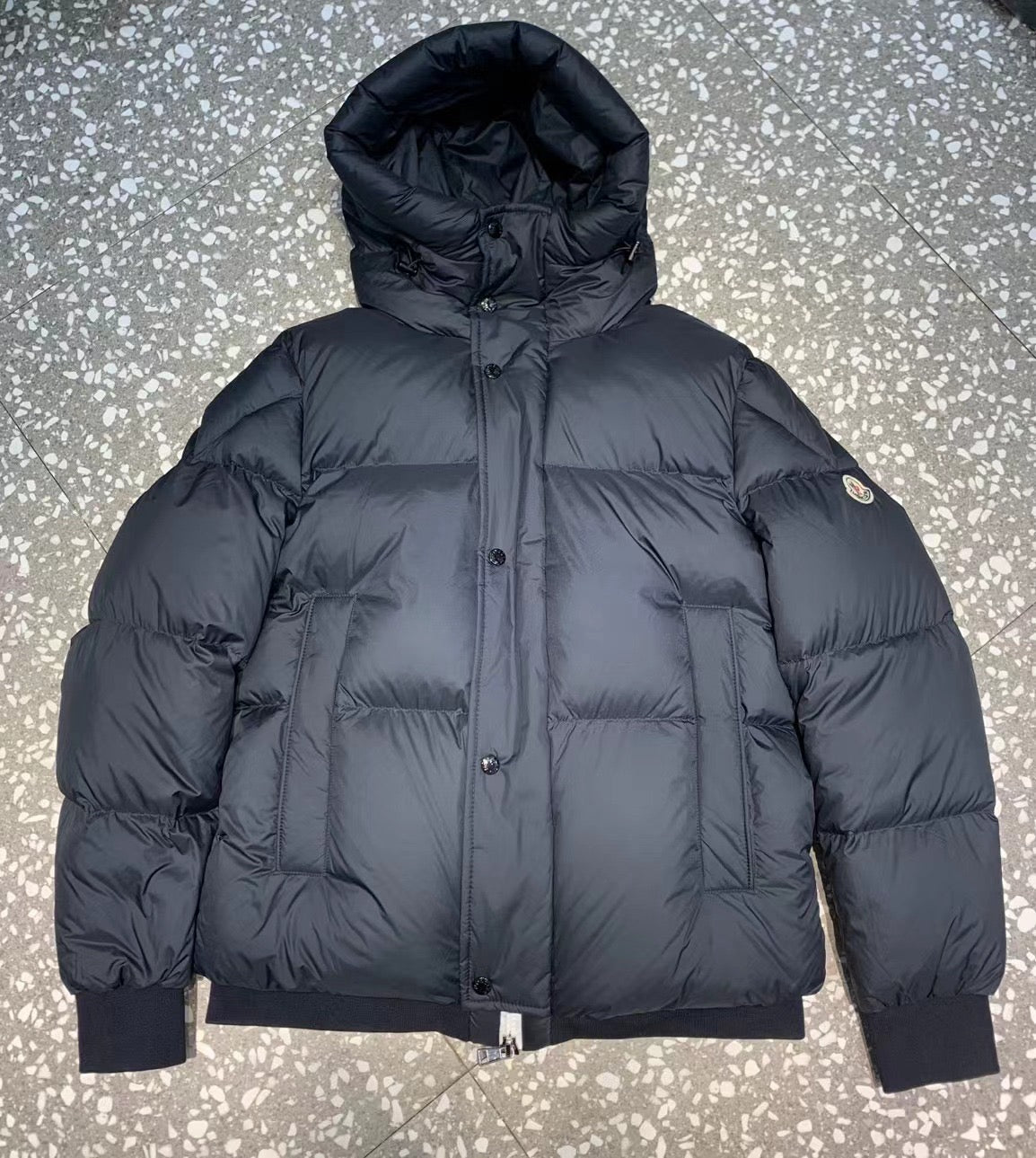Schwarze, blaue und weiße Jacke